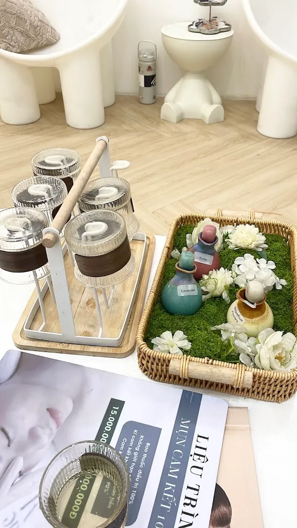 Không gian spa với khay tinh dầu, khăn và dụng cụ chăm sóc thư giãn.