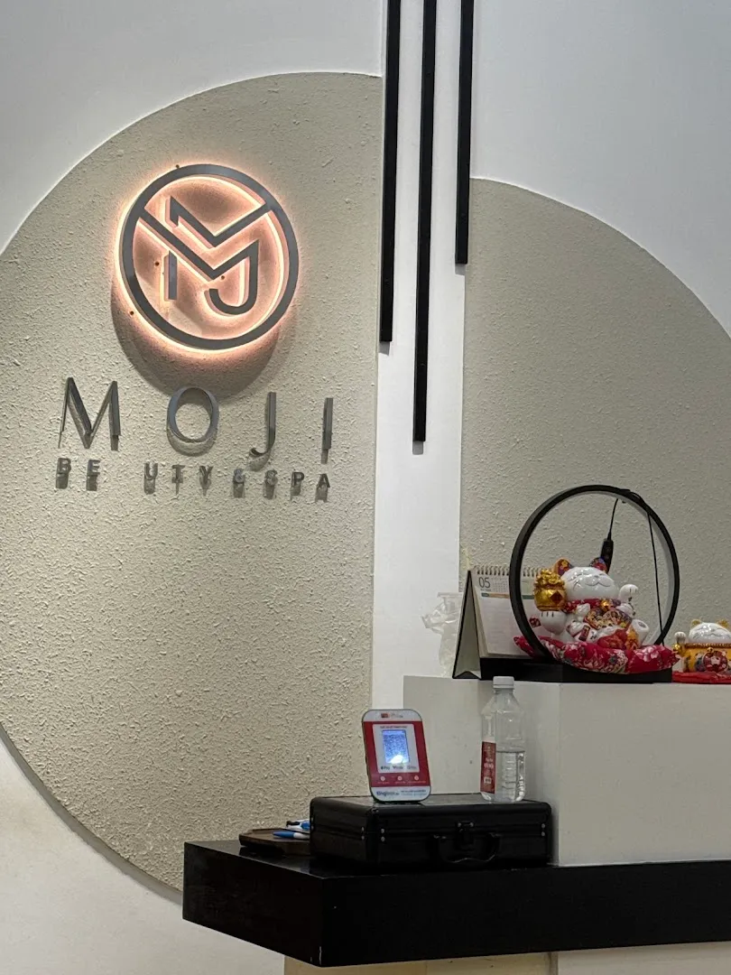 Khu vực quầy lễ tân với bảng hiệu MOJI BEAUTY SPA và biểu tượng thương hiệu.