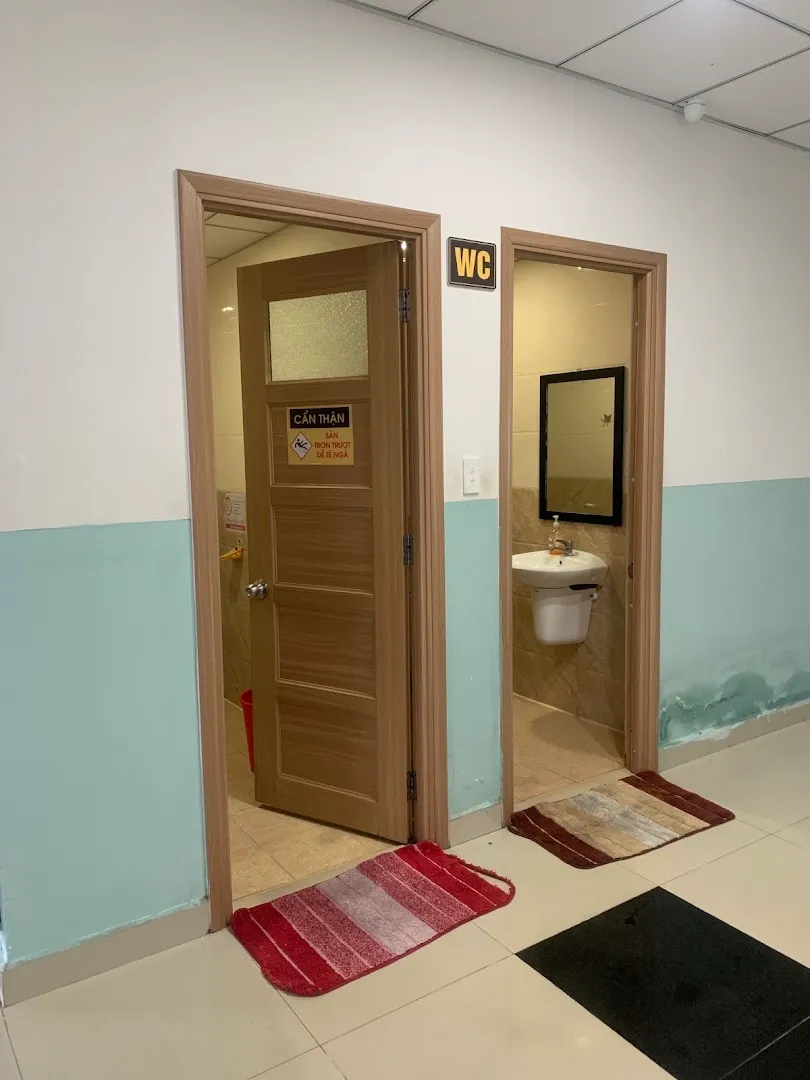 Khu vực nhà vệ sinh với biển chỉ dẫn WC và bồn rửa tay.