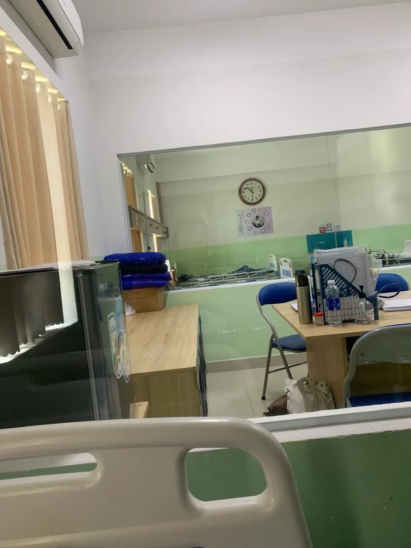 Phòng bệnh với giường bệnh, khu vực bàn làm việc và thiết bị y tế.