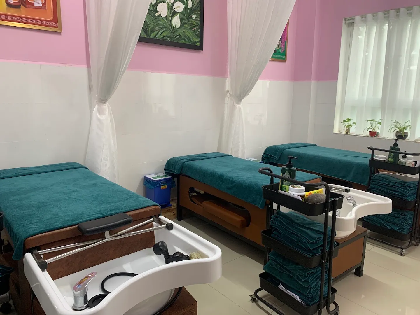 Phòng điều trị với các giường bệnh, bồn rửa và xe dụng cụ y tế.