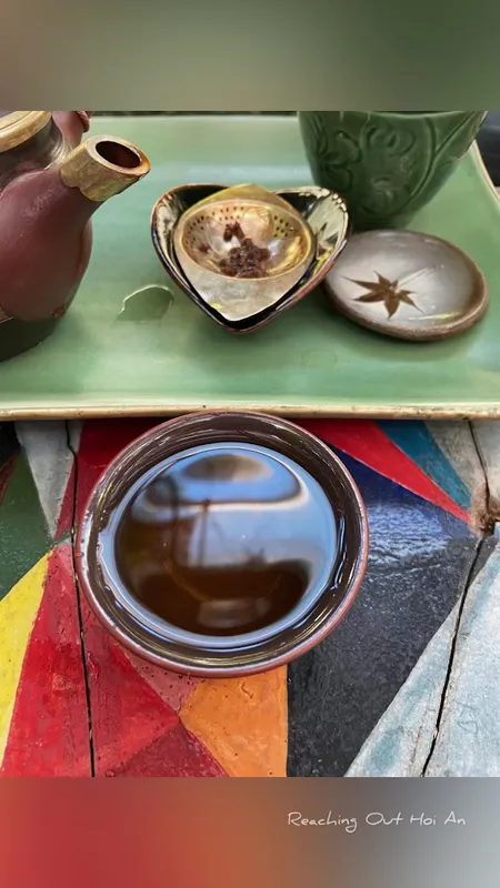 Bộ ấm trà gốm và chén trà trên khay trang trí.