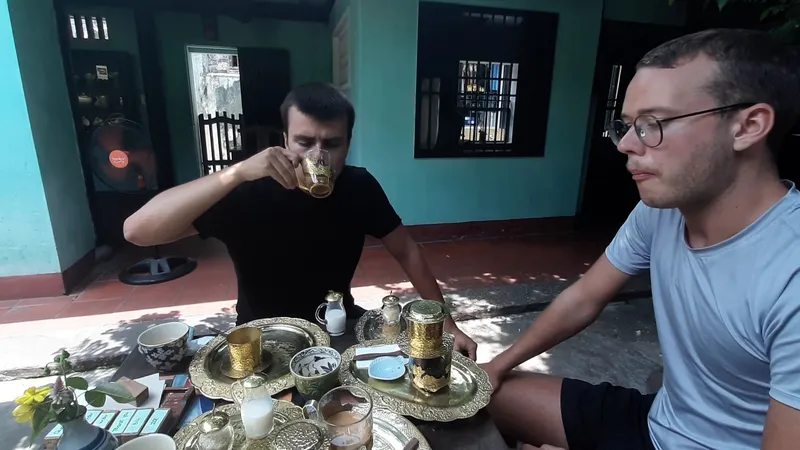 Hai người thưởng trà bên bộ ấm chén trang trí công phu trong không gian phòng trà.