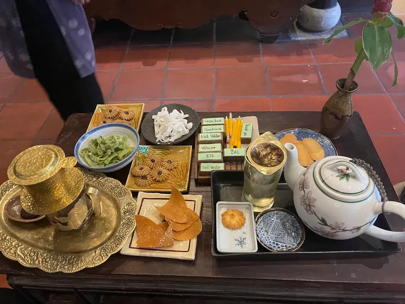 Bộ trà gồm ấm chén, trà, bánh và các món ăn nhẹ được bày trên khay.