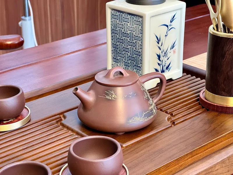 Bộ ấm chén và phụ kiện trà bằng gốm trên bàn trà.
