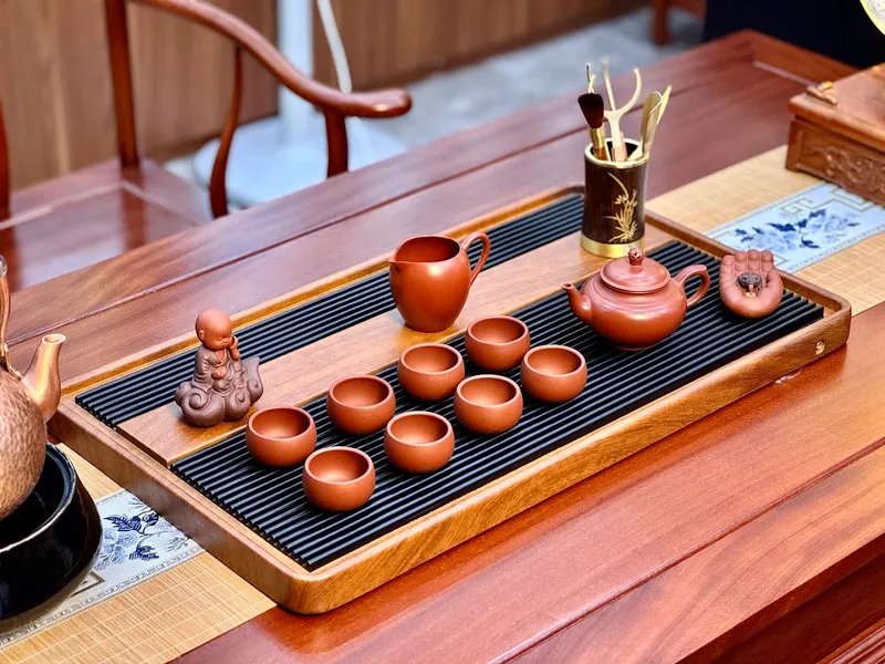 Bộ ấm chén và khay trà bằng gốm trên bàn trà.