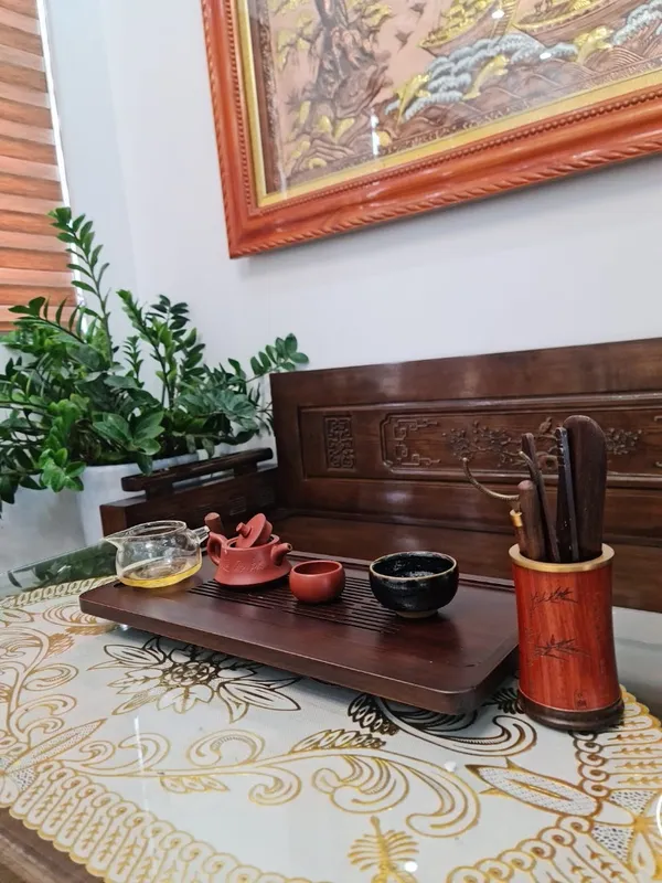 Bộ ấm chén trà bằng gốm được bày trên khay trà.