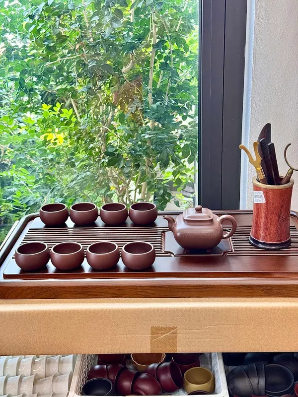 Bộ ấm chén trà bằng gốm được bày trên khay trà.