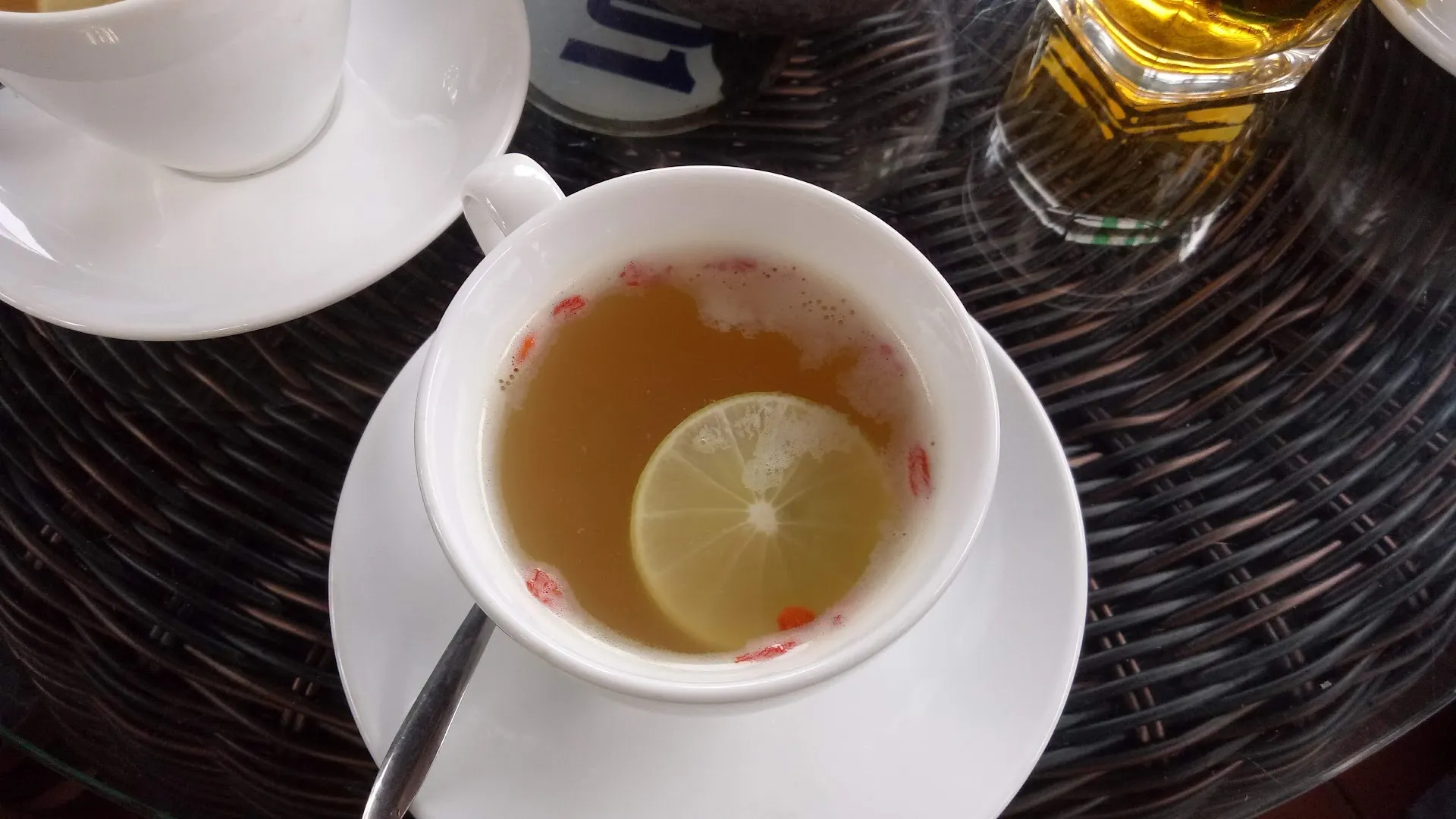 Tách trà nóng với lát chanh trên bàn cà phê