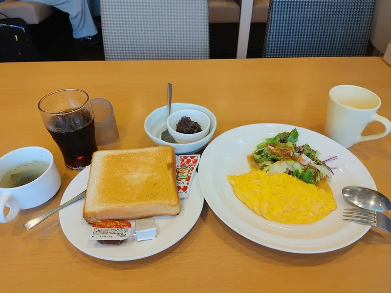 Bữa sáng gồm bánh mì nướng, trứng, salad, đồ uống và súp được phục vụ trên bàn.