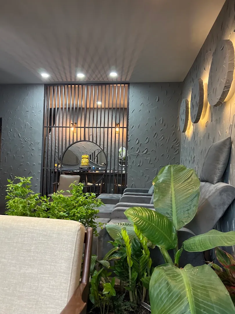 Không gian thư giãn với ghế ngồi, cây xanh và ánh sáng ấm áp.