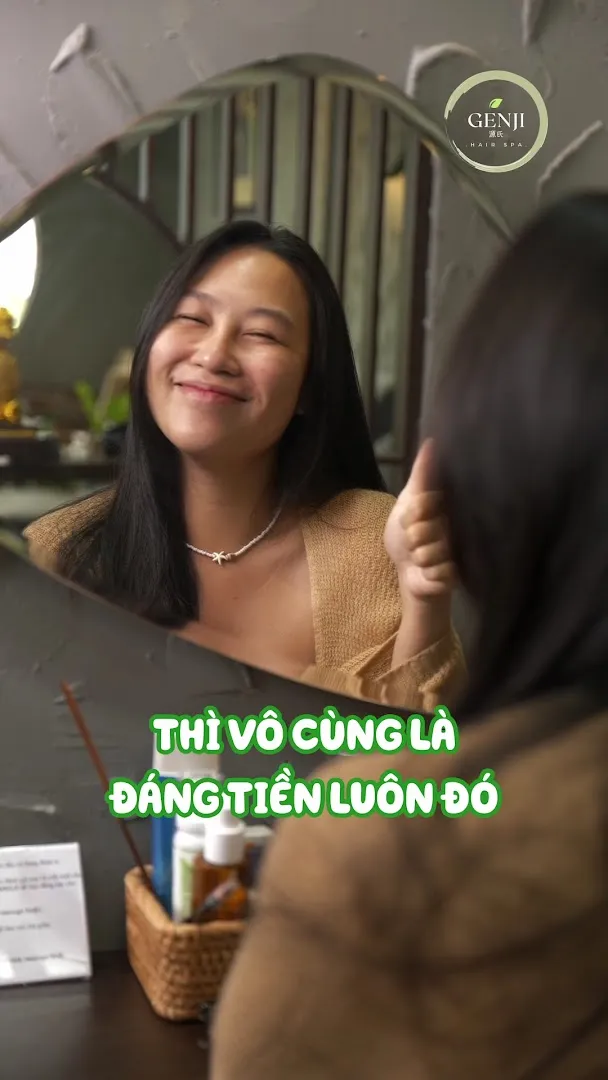 Khách mỉm cười trước gương trong không gian spa GENJI.
