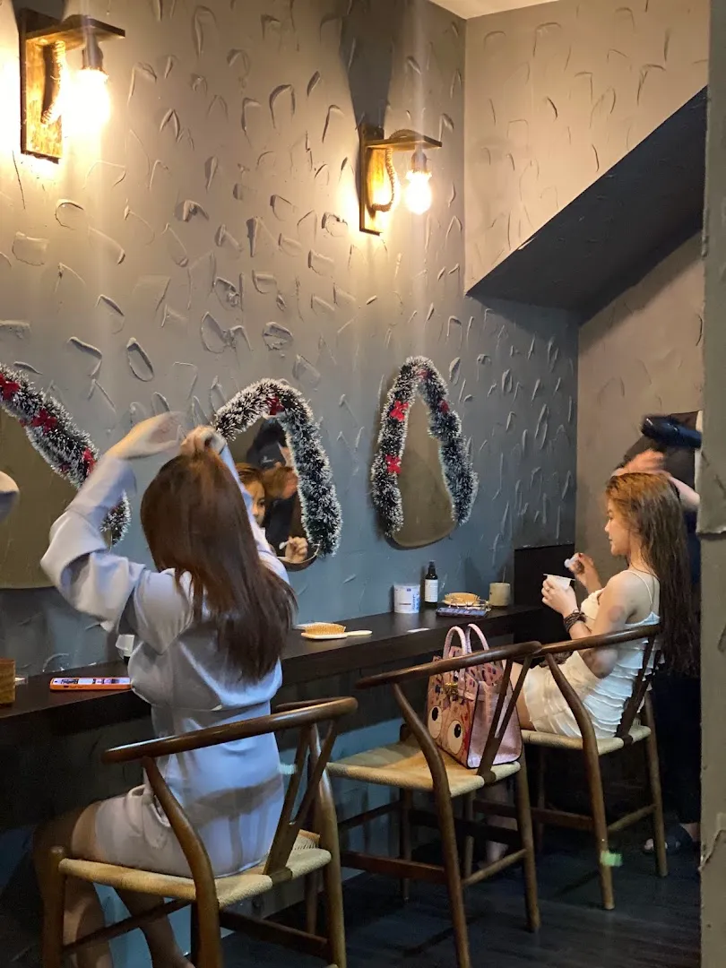 Không gian chăm sóc và làm đẹp với gương, bàn ghế và ánh đèn ấm áp.