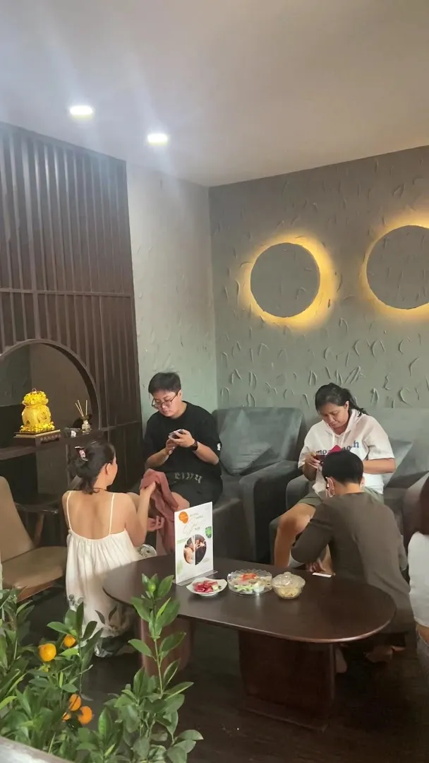 Không gian tiếp khách với ghế ngồi, bàn trà và ánh đèn trang trí.