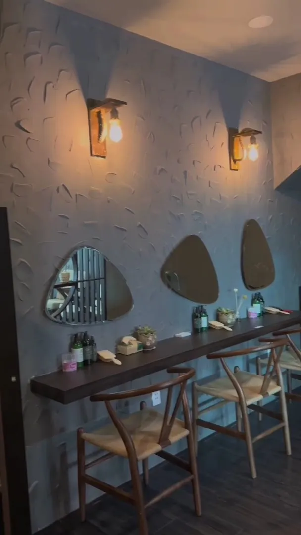 Không gian thư giãn với bàn ghế, gương trang trí và ánh đèn ấm áp.