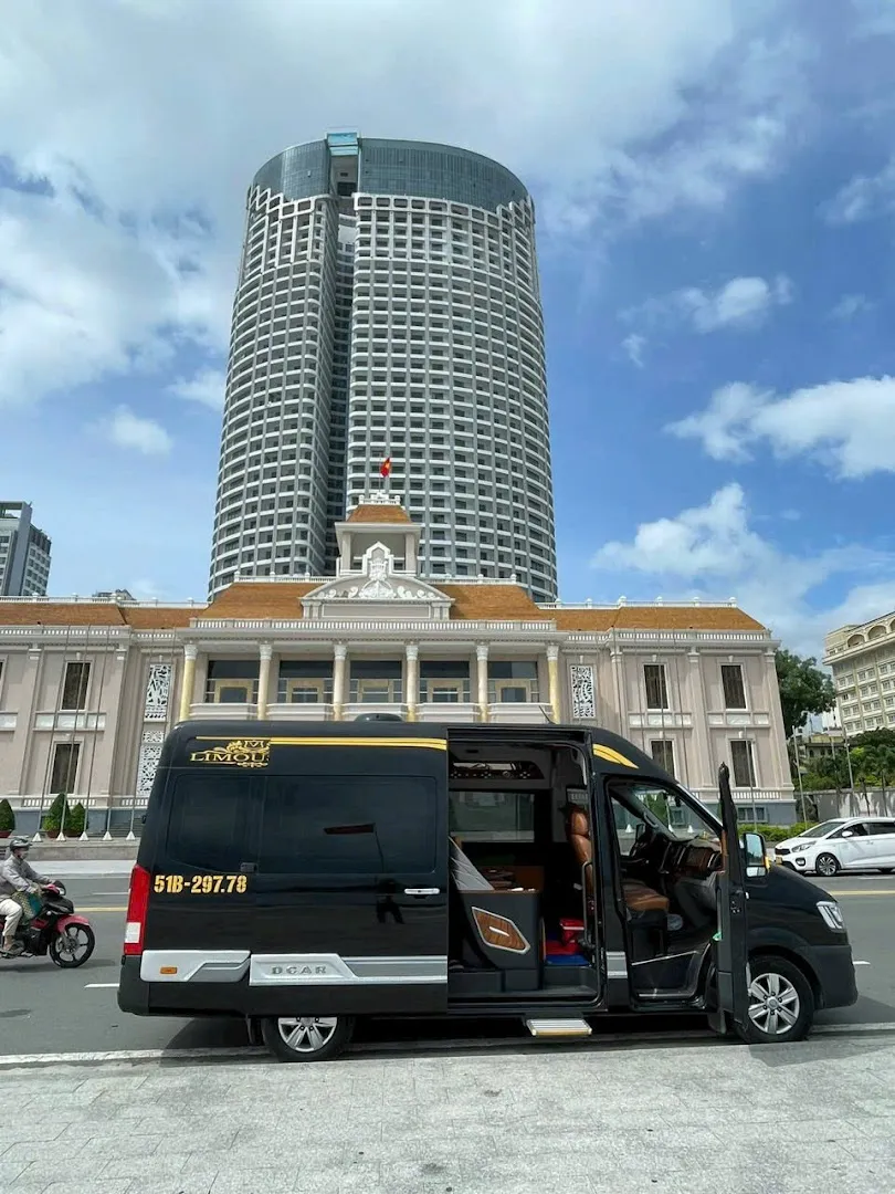 Xe limousine màu đen đỗ bên đường, cửa mở để lộ khoang ghế da.