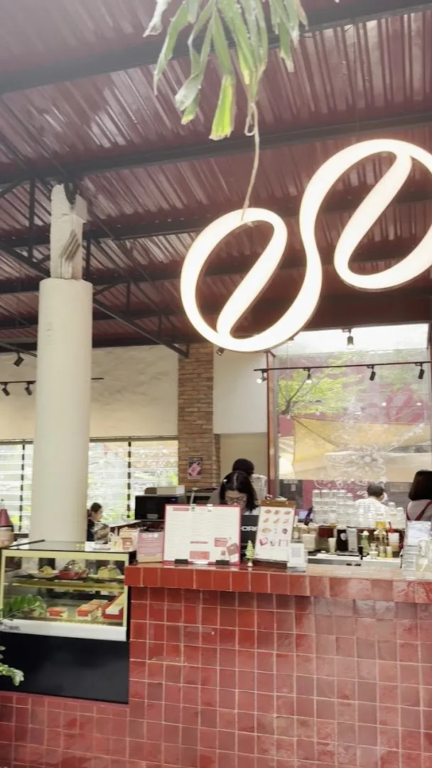 Quầy pha chế và khu trưng bày bánh trong không gian quán cà phê.