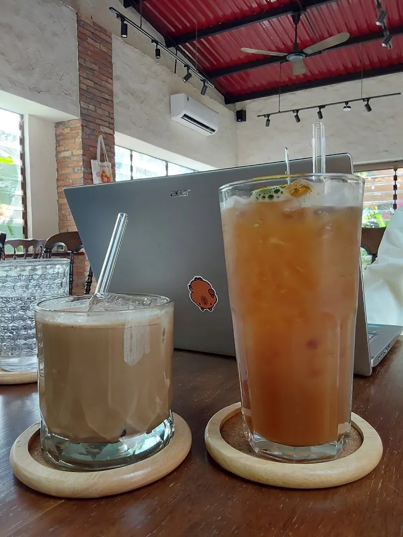 Hai ly đồ uống được phục vụ trên bàn trong không gian quán cà phê.