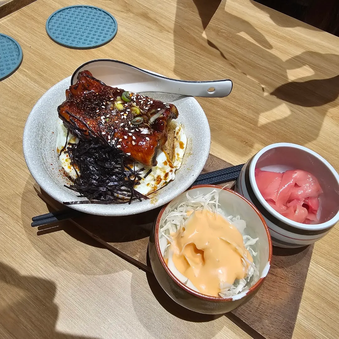 Món cơm phủ sốt với mè và rong biển, kèm salad bắp cải và gừng hồng.