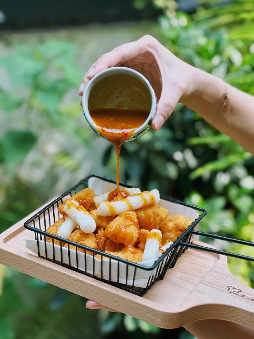 Đĩa đồ chiên giòn rưới sốt cam trong khay phục vụ.