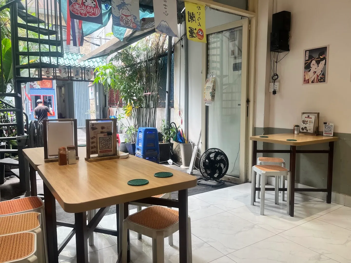 Không gian ăn uống với bàn ghế gỗ, các chi tiết trang trí phong cách Nhật và khu vực ngồi thoáng sáng.