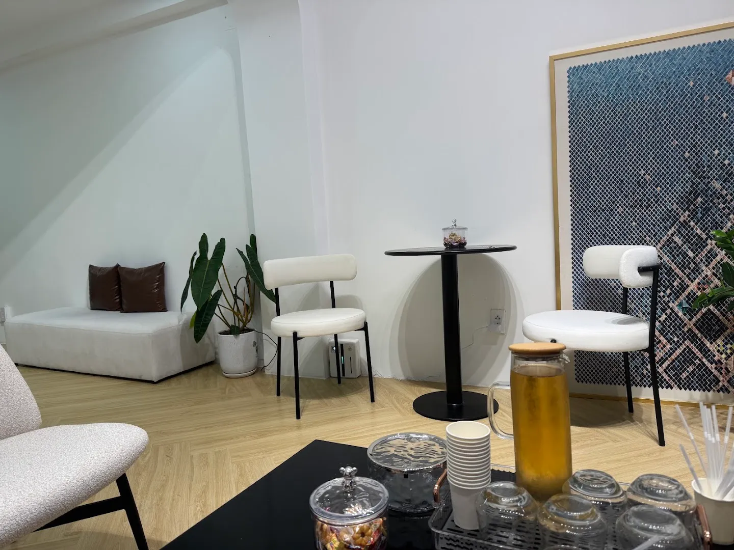 Không gian spa sáng thoáng với ghế thư giãn, bàn trà và cây xanh.