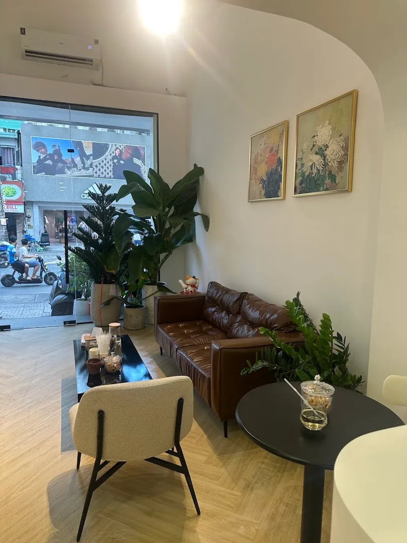 Không gian sảnh chờ với sofa, bàn trà và cây xanh.
