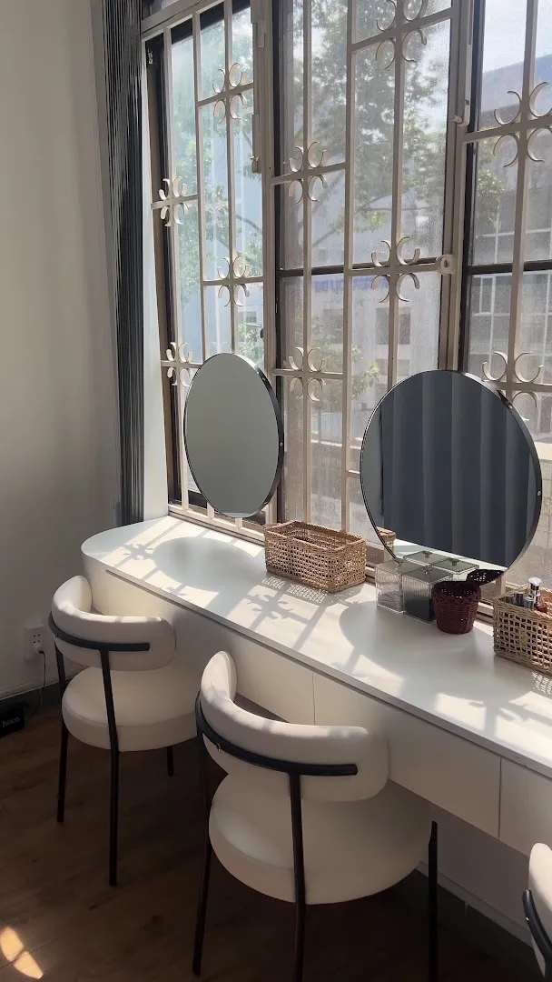 Khu vực bàn trang điểm với gương và ghế ngồi trong không gian spa.