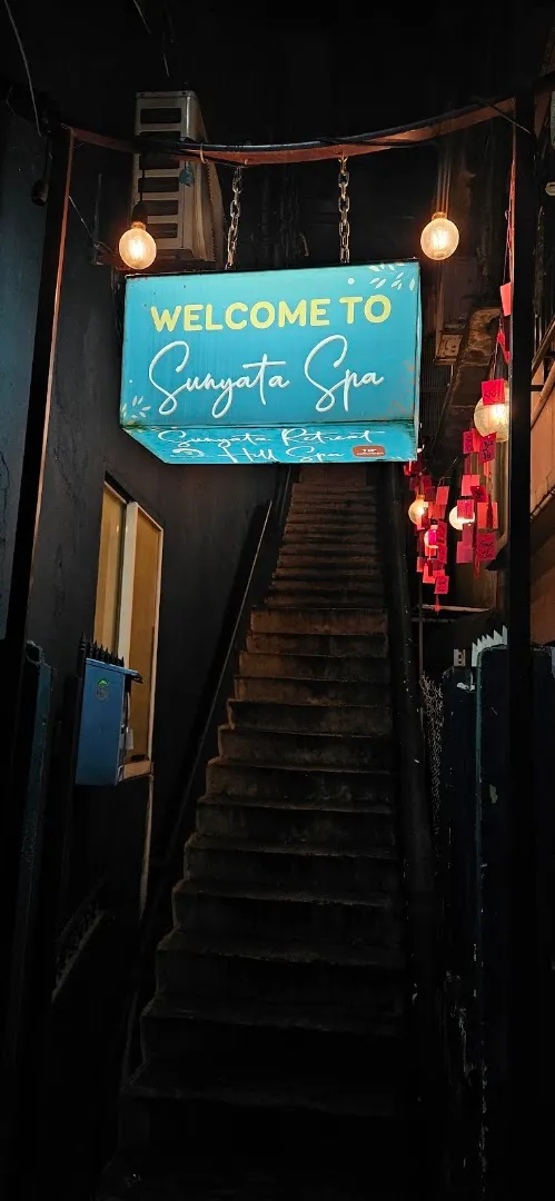 Lối cầu thang dẫn vào Sunyata Spa với bảng chào đón và đèn trang trí.