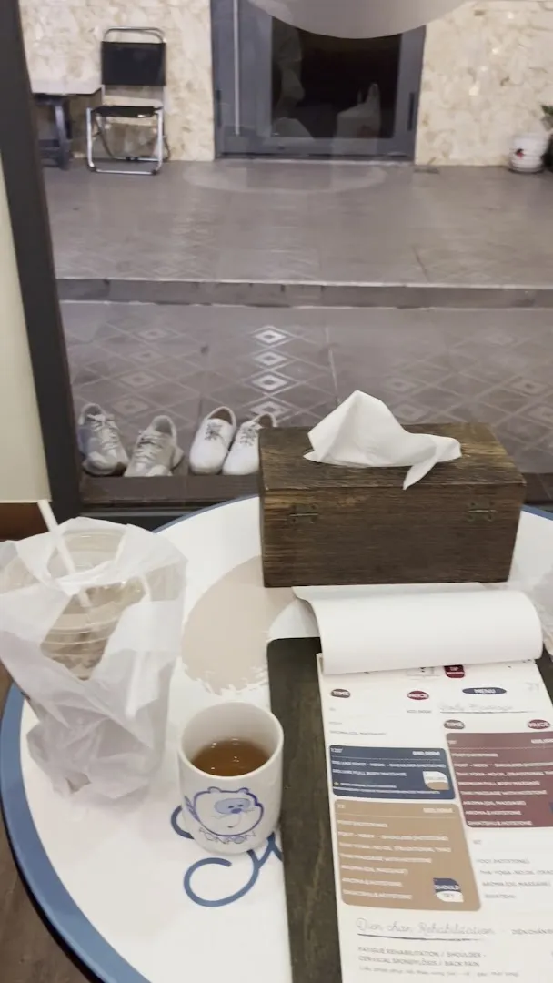 Bàn trà với khăn giấy, đồ uống và tài liệu đặt trong không gian thư giãn.