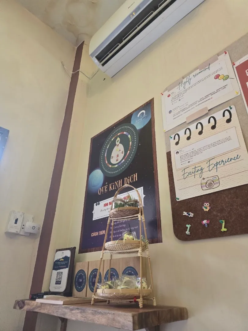 Góc trang trí trong nhà với bảng thông tin, mã QR và kệ trưng bày nhỏ.