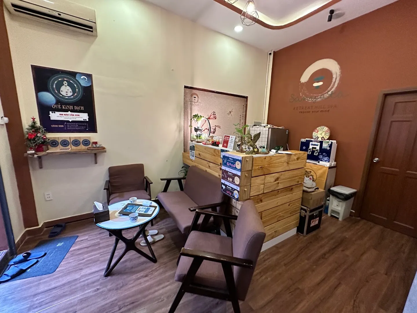 Khu vực lễ tân và phòng chờ của spa với ghế ngồi và quầy gỗ.