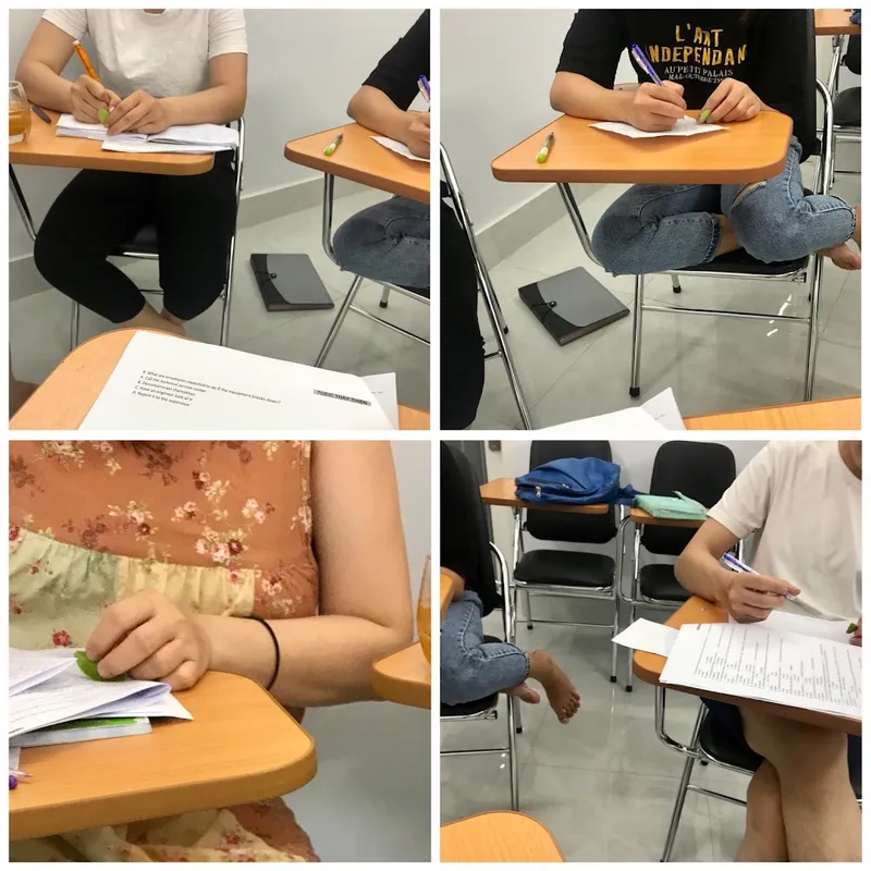 Học viên làm bài trong lớp học với bàn ghế và tài liệu luyện thi.