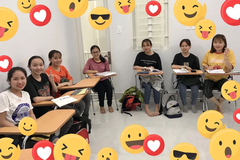 Lớp học với học viên ngồi tại bàn và tài liệu học tập.