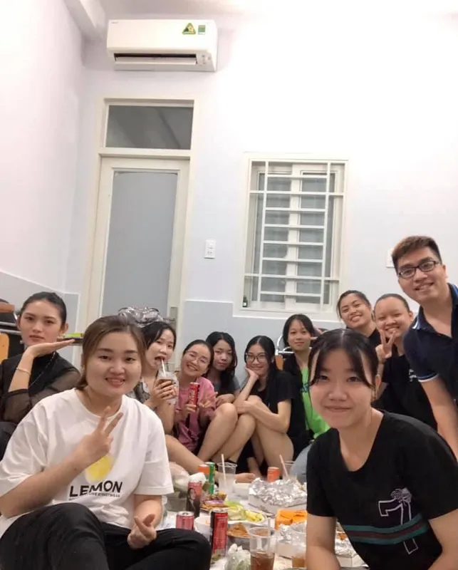 Nhóm người chụp ảnh trong một phòng sinh hoạt, dùng bữa cùng nhau.