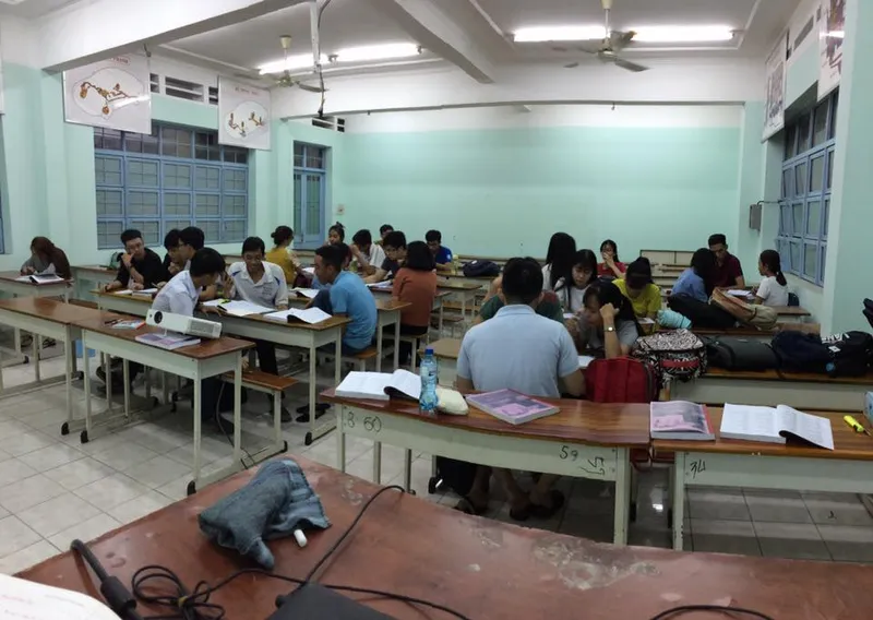 Không gian lớp học với học viên đang học tập tại bàn.