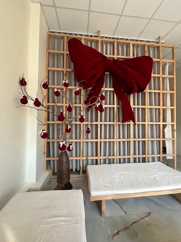 Spa treatment room with two treatment beds and festive red bow decor