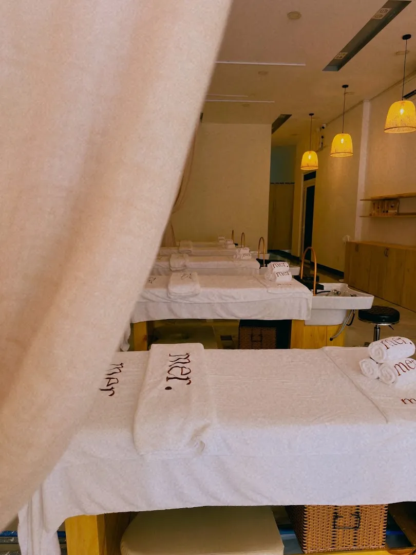 Không gian phòng spa với các giường trị liệu được chuẩn bị bằng khăn sạch và ánh đèn ấm áp