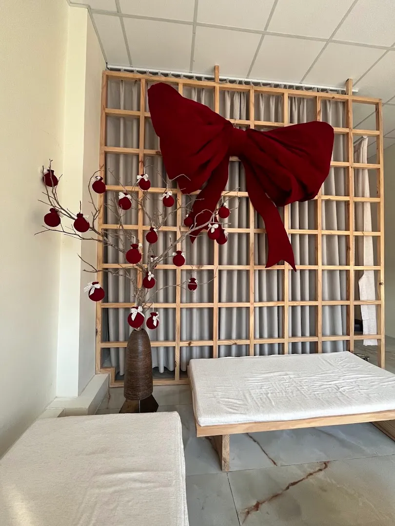 Không gian phòng spa với hai giường trị liệu và vách ngăn trang trí.