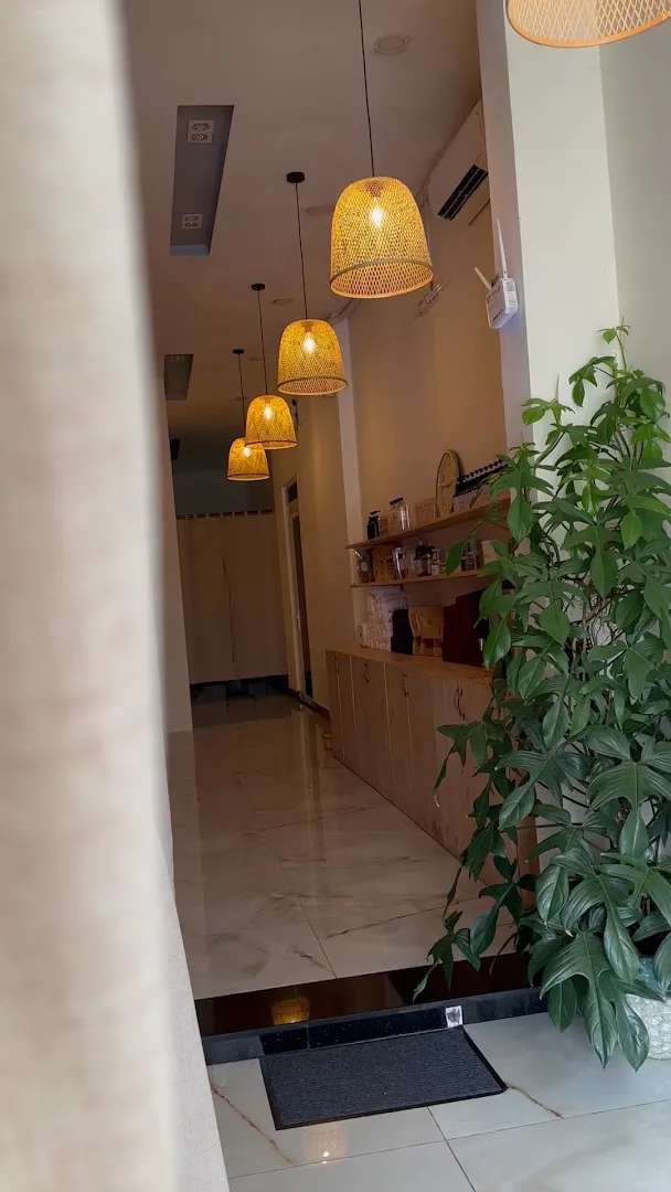 Không gian nội thất ấm cúng với đèn mây, quầy kệ và cây xanh.