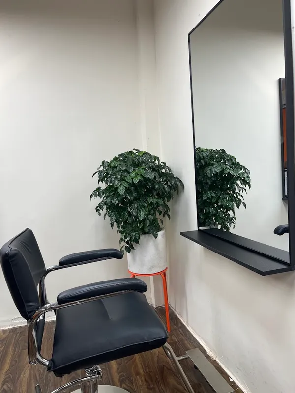 Ghế làm tóc và gương lớn trong không gian salon.