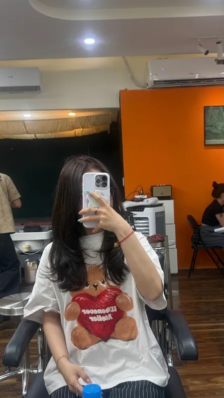 Không gian salon với ghế làm tóc và khách đang ngồi trước gương.