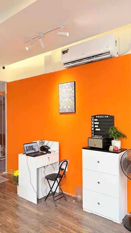 Không gian nội thất với tường cam, khu vực bàn làm việc và nội thất gọn gàng.