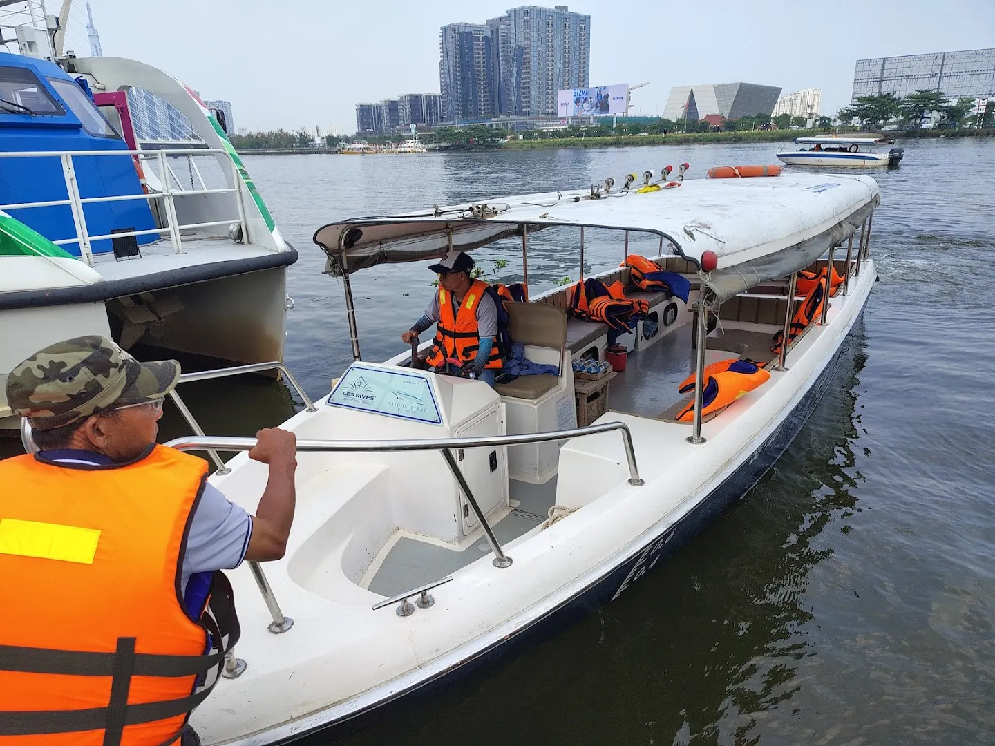 Thuyền du lịch Les Rives trên sông với áo phao và người điều khiển thuyền.