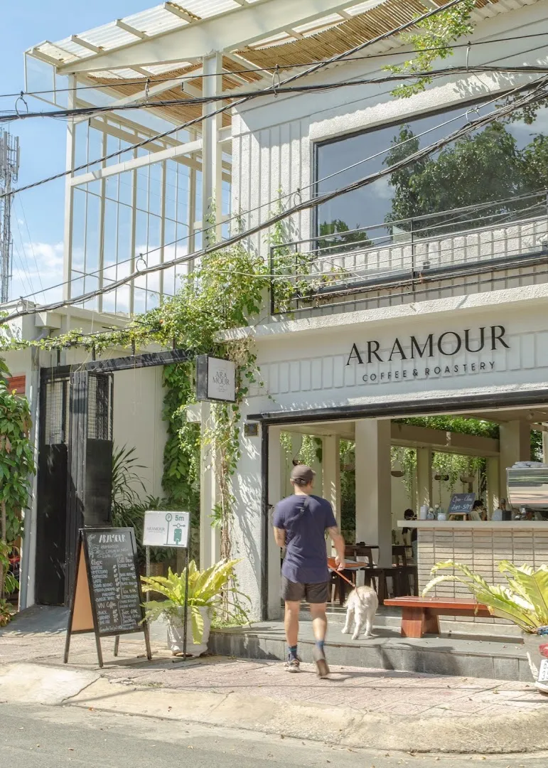 Mặt tiền Aramour Coffee & Roastery với lối vào và bảng thực đơn phía trước.