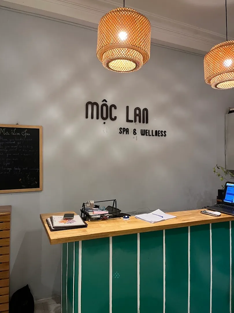 Quầy lễ tân của Mộc Lan Spa & Wellness với bảng hiệu và đèn mây trang trí.