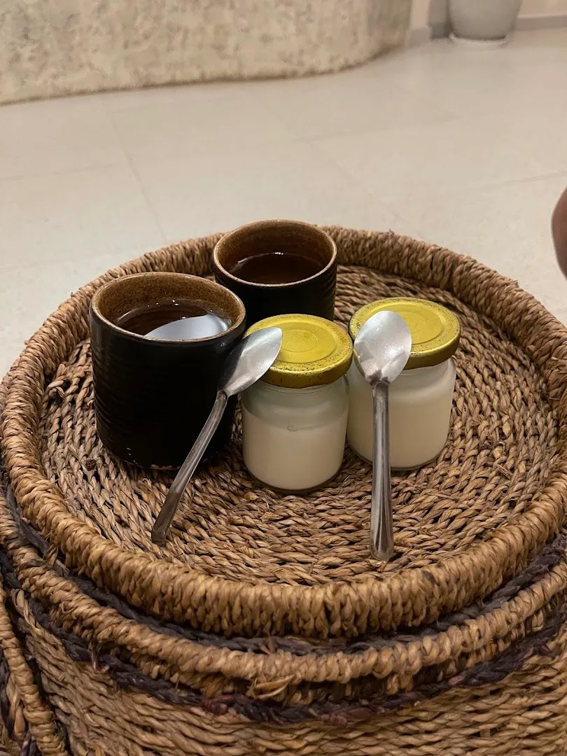 Khay mây đựng các hũ kem và cốc đồ uống trong không gian thư giãn.