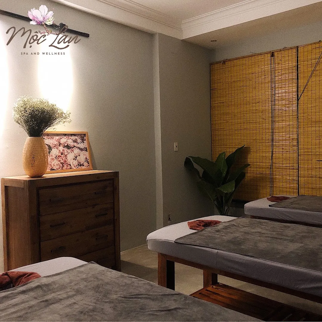 Không gian phòng trị liệu với các giường spa, rèm tre và nội thất gỗ ấm cúng.