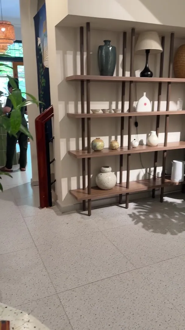Kệ trang trí với bình gốm, đèn và các vật dụng tạo điểm nhấn cho không gian spa.