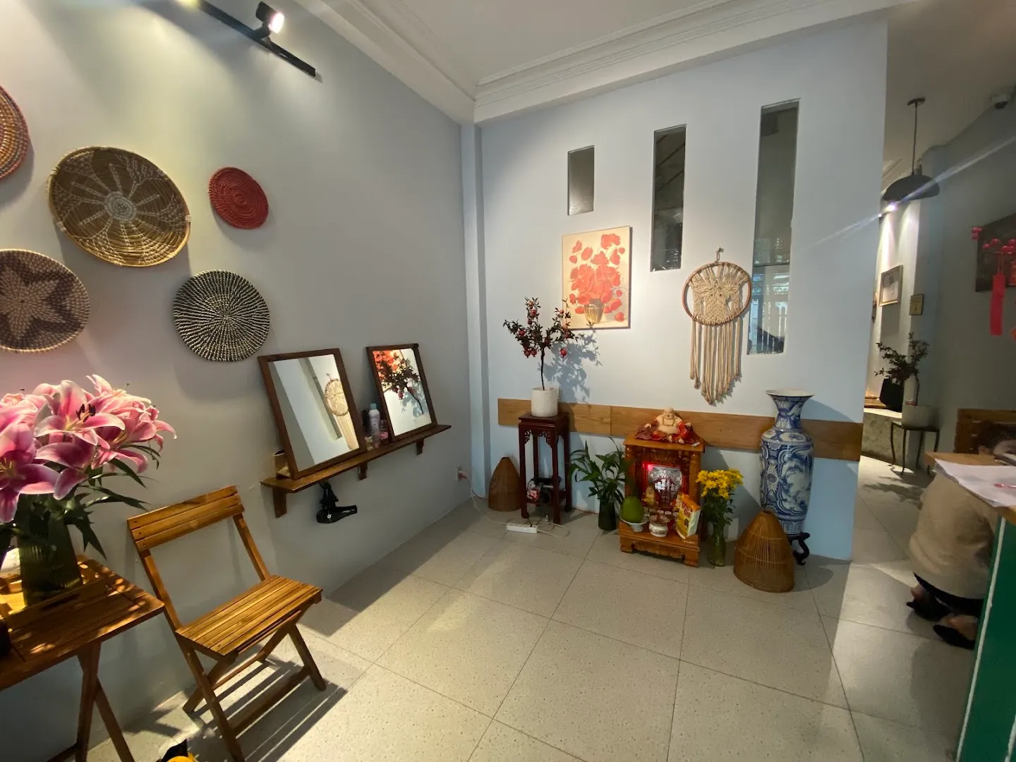 Không gian sảnh thư giãn với ghế chờ, tranh trang trí và cây xanh.
